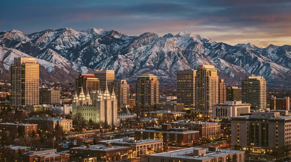 Downtown Salt Lake City skyline at dusk with the snow-capped Wasatch behind